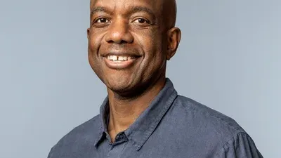 A headshot of James Manyika, Google’s SVP of Research, Labs, Technology & Society. He is wearing a dark blue, button-down collared shirt.
