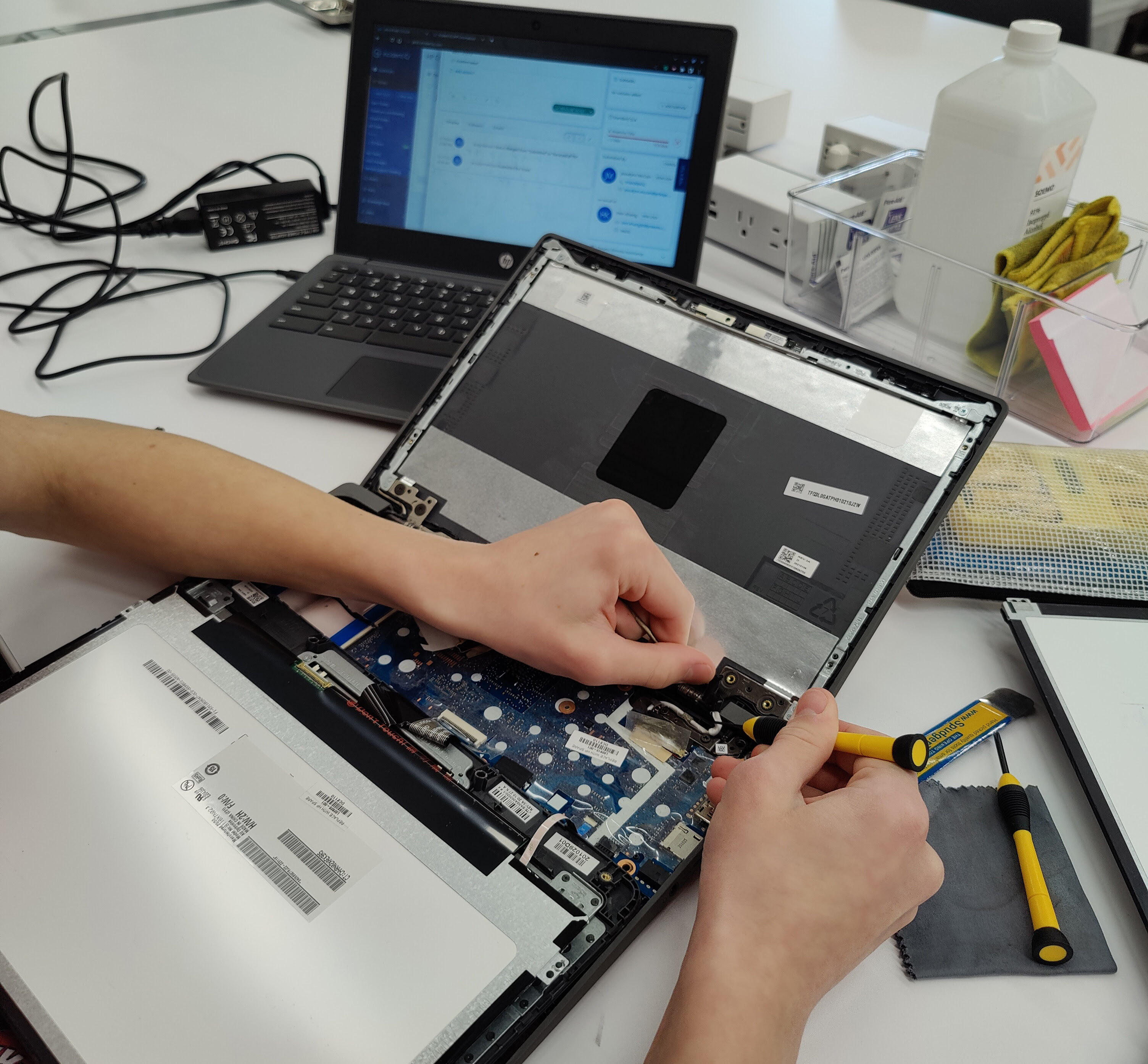 A student repairs a Chromebook computer