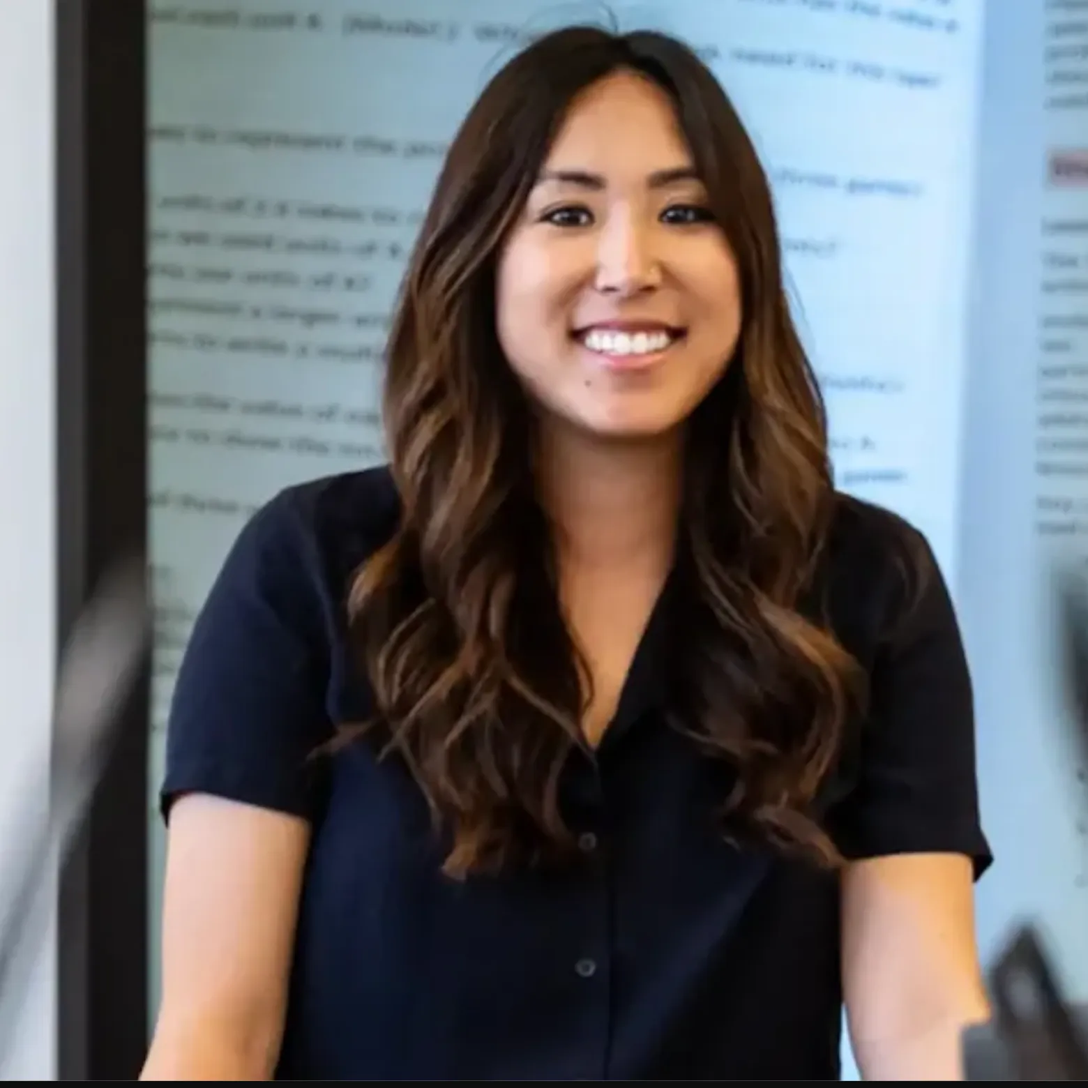 A teacher stands in front a projector screen in a school setting