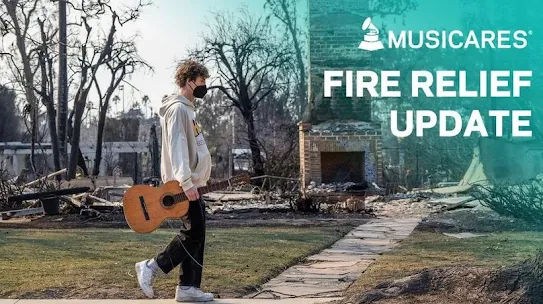 image of young man walking with guitar in hand in front of fire wreckage
