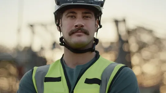 A man poses in a hard hat