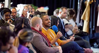 A guy speaking something on mic among the group of people