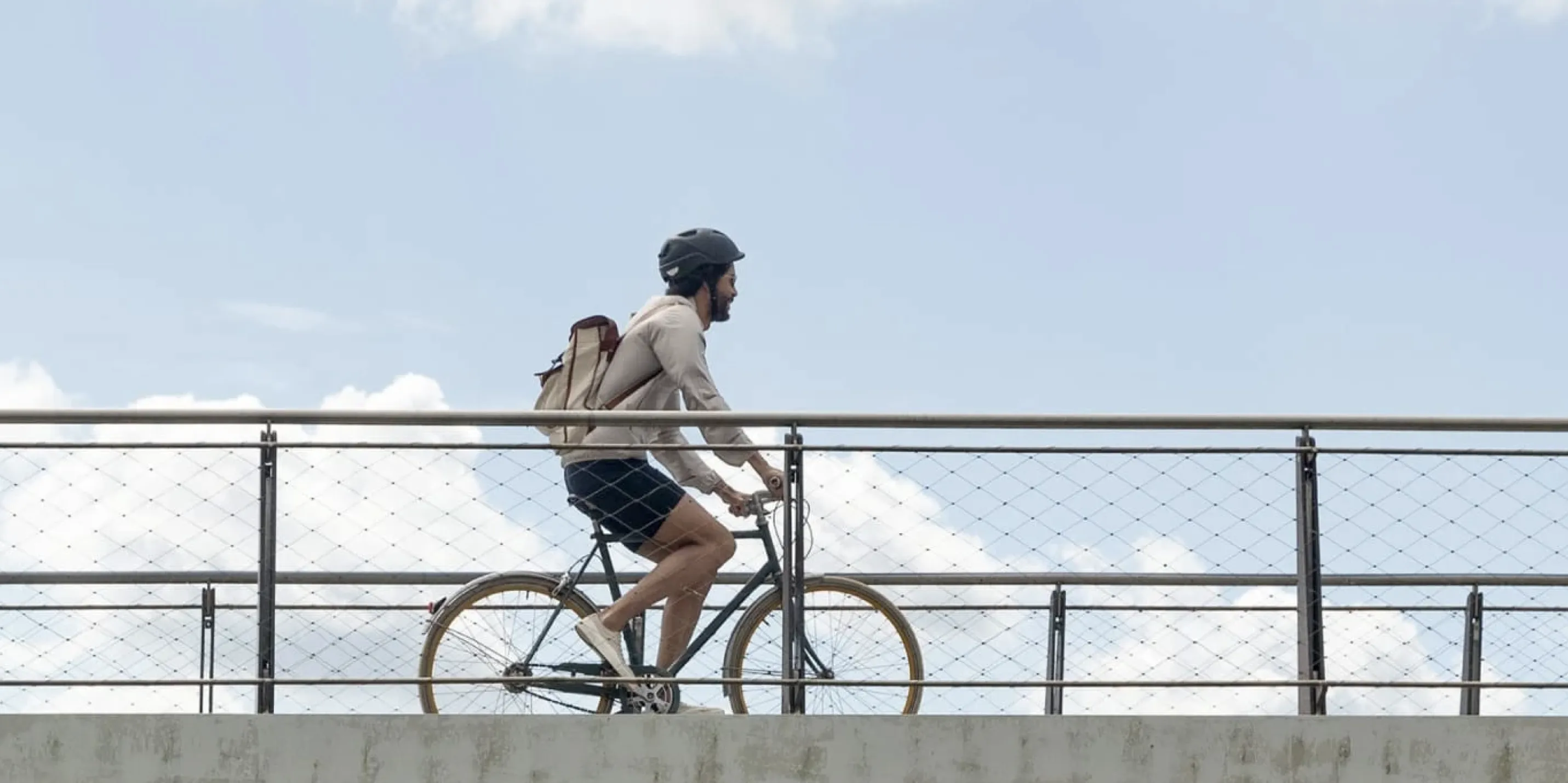 Ein Mann mit Rucksack und Helm auf einem Fahrrad