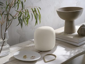 Image of Nest Wifi product on a table with tabletop accessories
