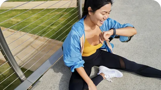 Frau sitzt und schaut auf ihre Smartwatch