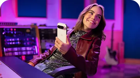 Woman sitting in a sound studio holding an Android phone