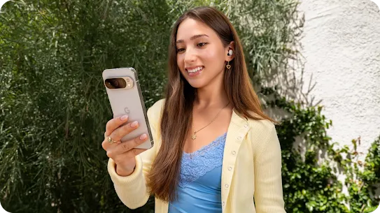 Woman standing in a park looking at her Android phone