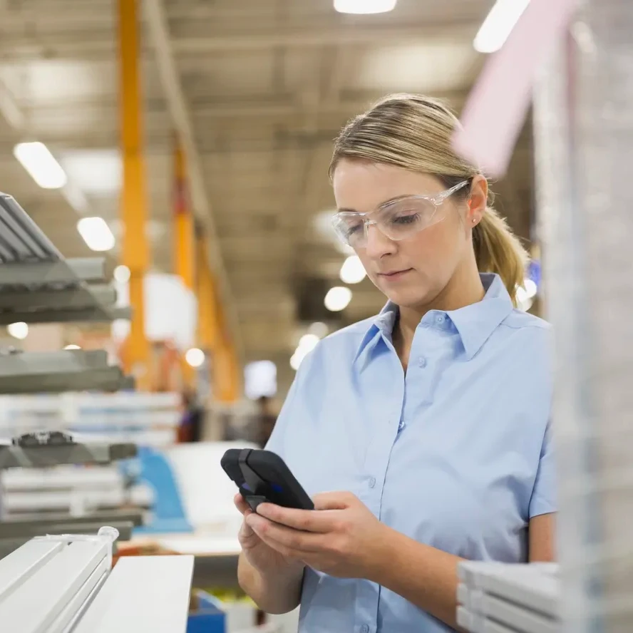 A warehouse worker uses a smart device to help manage inventory