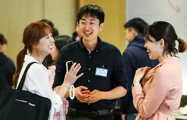 Two women and a men discussing something and laughing.