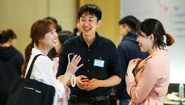 Two women and a men discussing something and laughing.