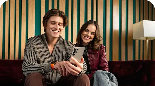 Man and woman sitting together looking at Android phone