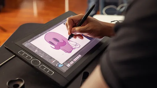 Julius Hubbard sketches a character design on a drawing tablet.