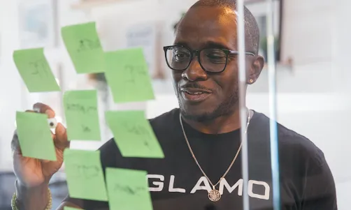 A man writing something on a sticky note.