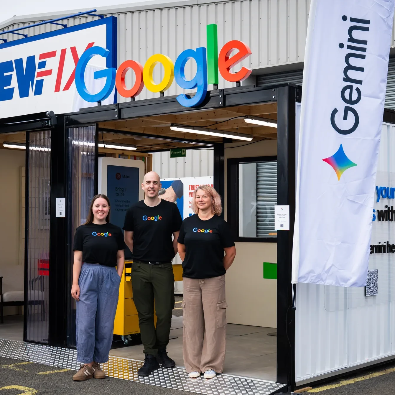Four men in workwear interact at a Google promotional booth outside a hardware store.