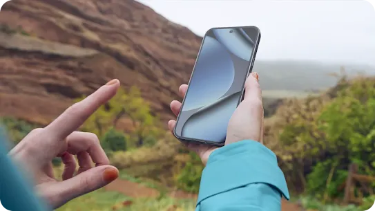 A woman using an Android phone in the wilderness.