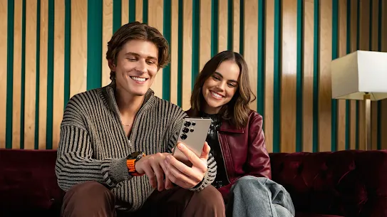 Man and woman sitting together looking at Android phone