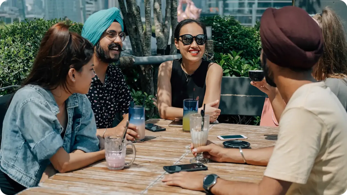 Four customers enjoy the drinks that they purchased using Tap and Pay on their smartphones.