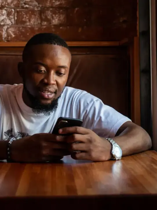 Man sitting in cafe looking at his phone