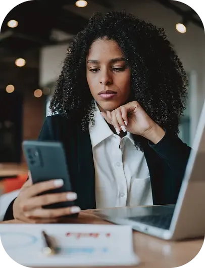 Woman looking at phone with a scam detection alert and option to report and block