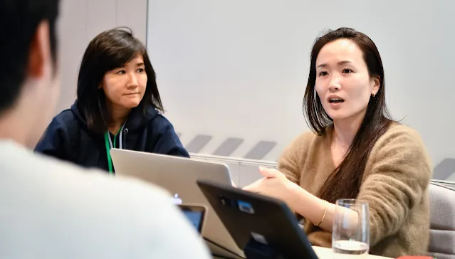 A woman explaining something and a man and woman looking at her.