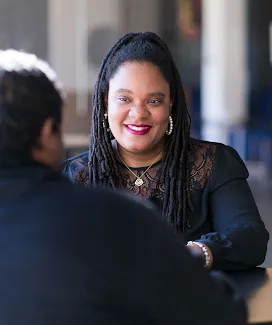Woman chatting with a man, smiling.