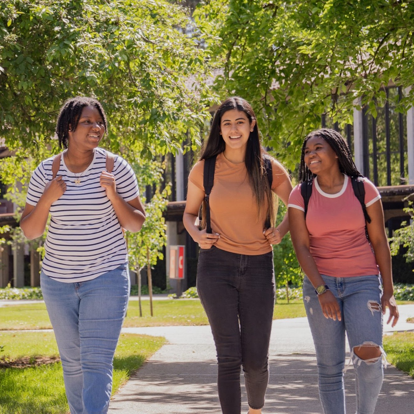 Three college students walk across campus