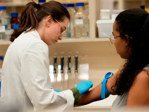 Healthcare professional collects blood from the patient.