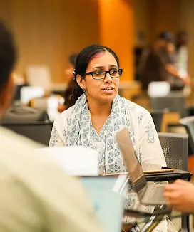 A lady listening intent to a colleague at a social gathering.