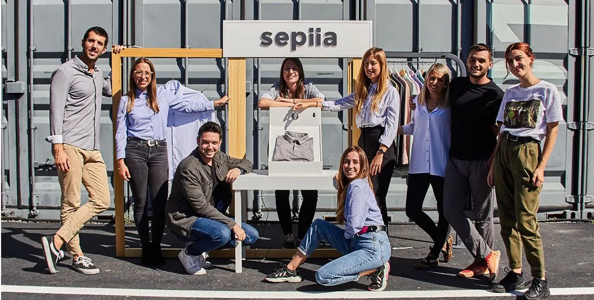The team of Sepiia pose in front of their sign outside.