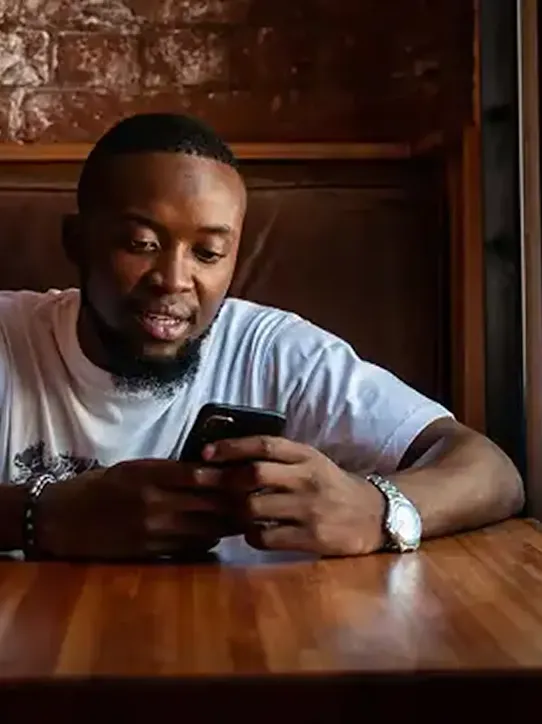 Man sitting in cafe looking at his phone