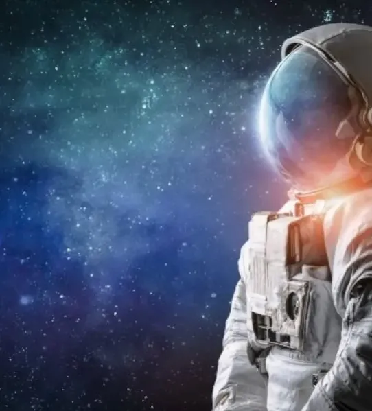 An astronaut in a white space suit looking at a glowing star field and nebula in deep space.
