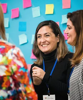 The volunteer lady is instructing a group of women at the stall.