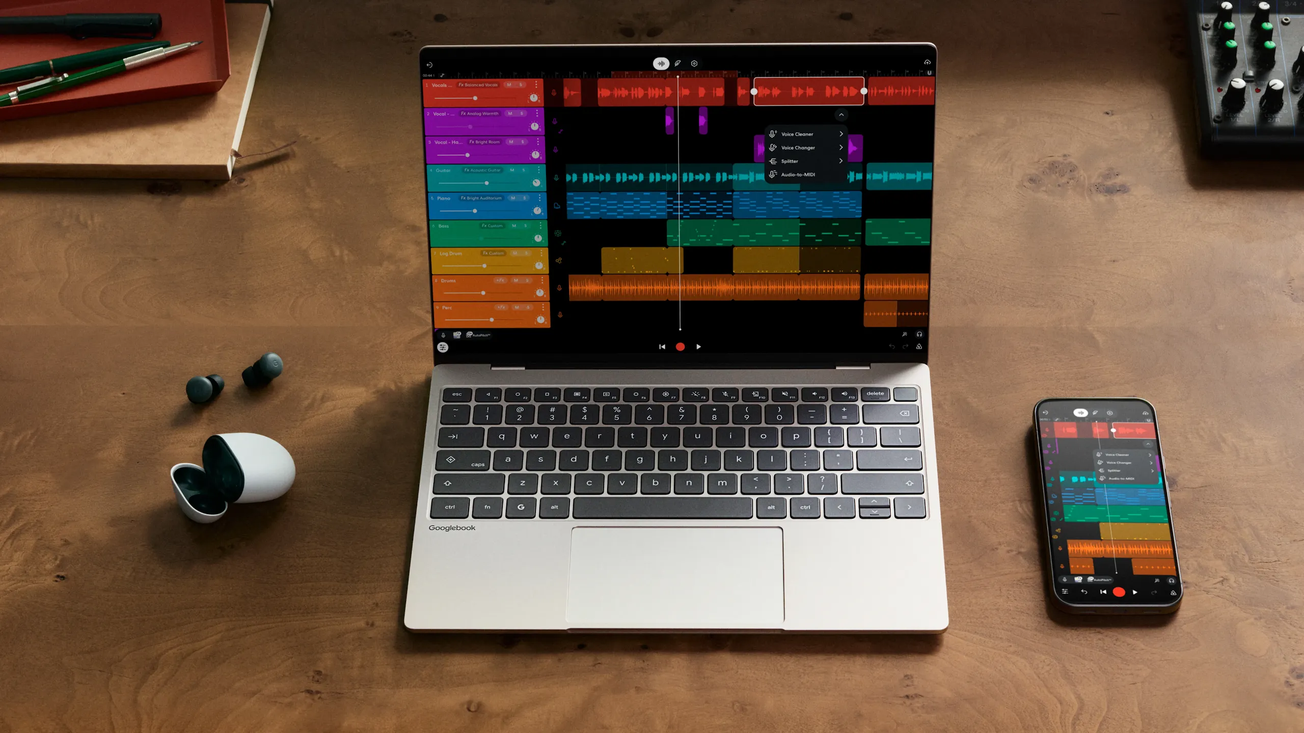 A Googlebook laptop and Android phone side by side on a wooden desk, both displaying a music production app.