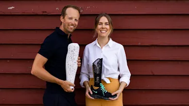 Emelie and Christian, co-founders of Anatomic Studios, looking at the camera and smiling while holding the prosthesis they designed.