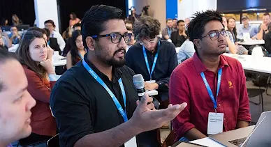 An audience member with a mic questioning the host.