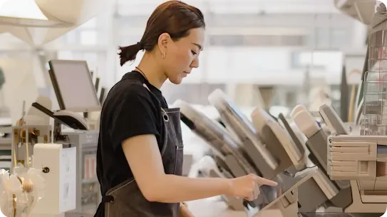 Coffee shop employee tapping on a tablet.