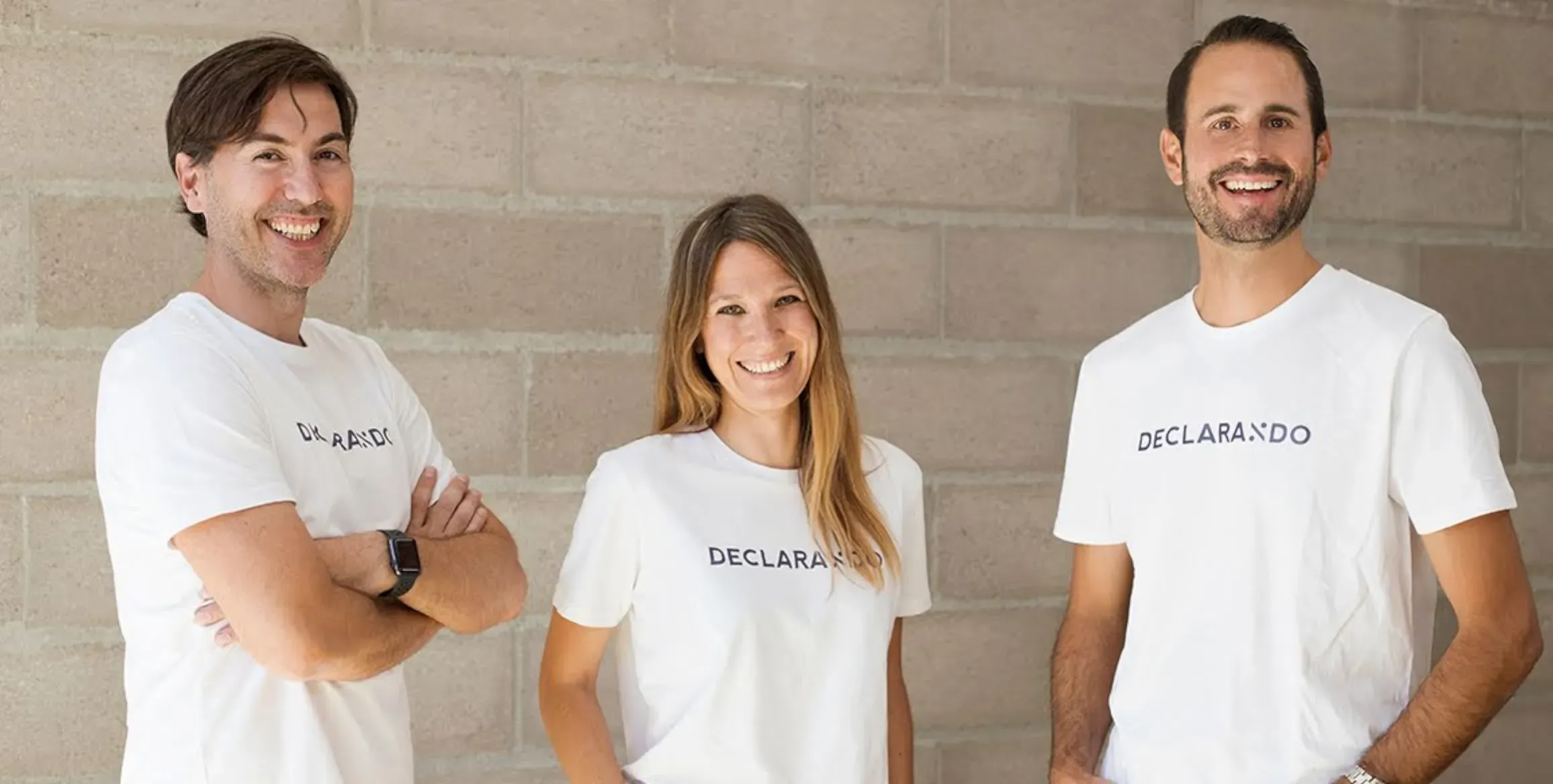 Founding team members of Declarando are posing against a wall with matching shirts.
