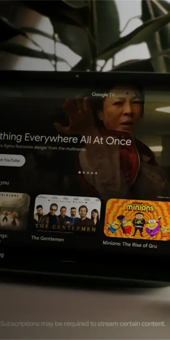 A tablet displaying Google TV homepage, Circle to Search, a boomerang of people jumping into a lake, and a YouTube Music song to which an old couple is dancing to.