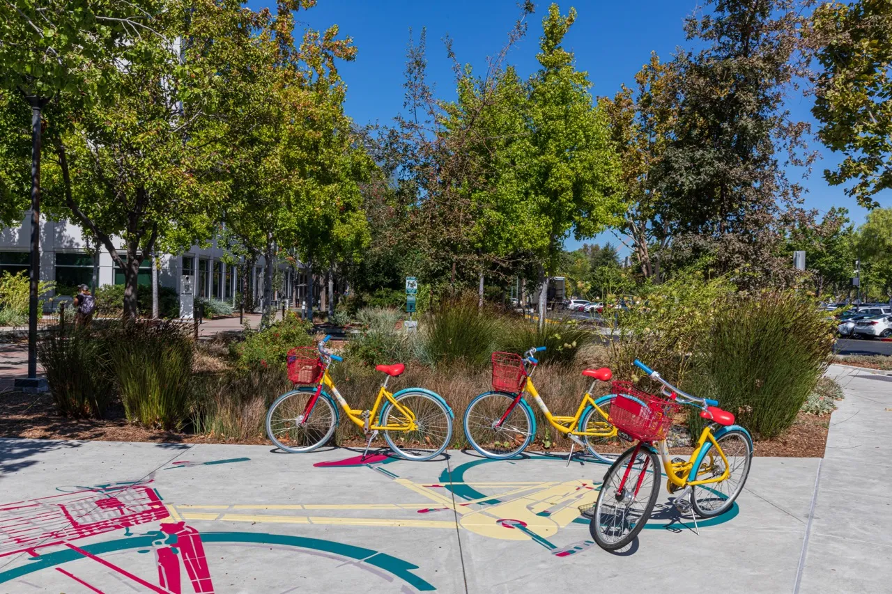 Trois vélos Google stationnés devant un bâtiment