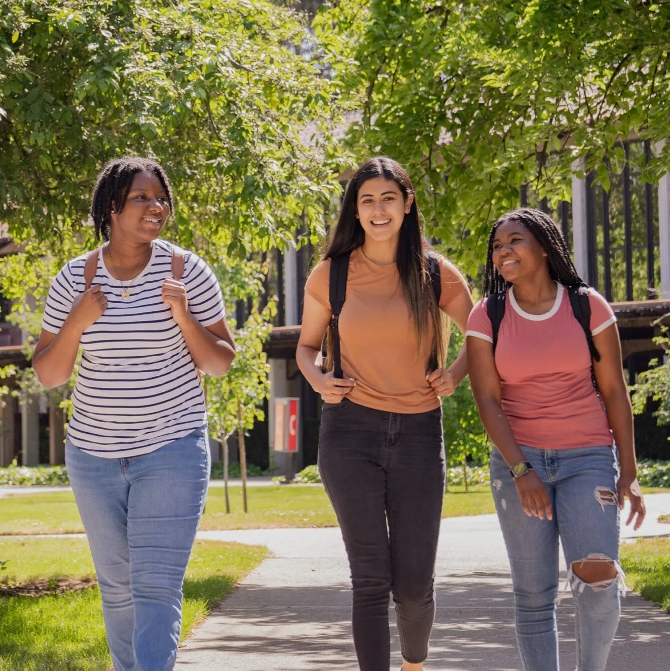 Three college students walk across campus