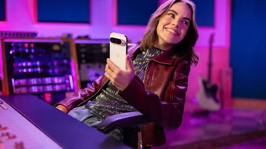 Woman sitting in a sound studio holding an Android phone