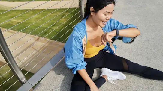 Woman sitting and looking at her smartwatch