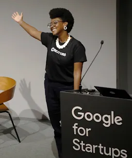 A women wearing a black t-shirt showing something by directing a hand.