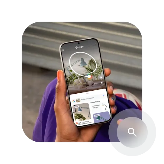 A hand holding a phone with the screen showing an abstract example of how the Circle to Search feature works.