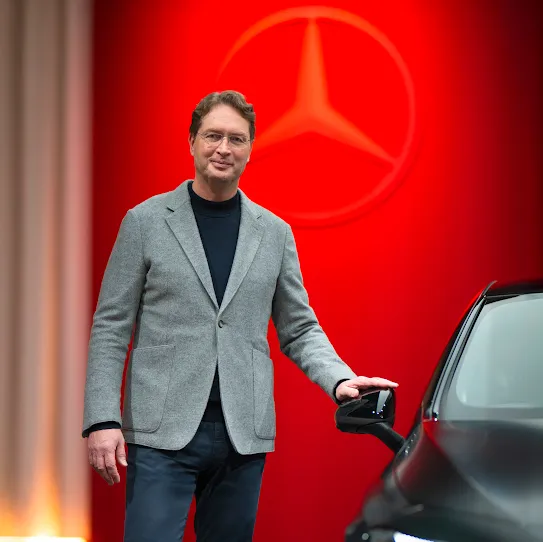 Ola Källenius (CEO Mercedes-Benz) neben Auto. Zitat: Google-Kooperation macht KI-Navigation zum Begleiter, der Insassen versteht.