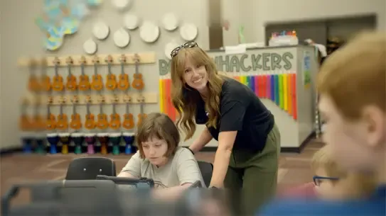 teacher working with students around a table