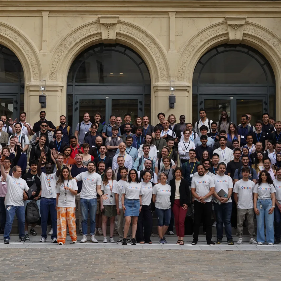 More than 100 participants in Google France's health hackathon gather in front of a building in Paris on a bright, sunny afternoon.