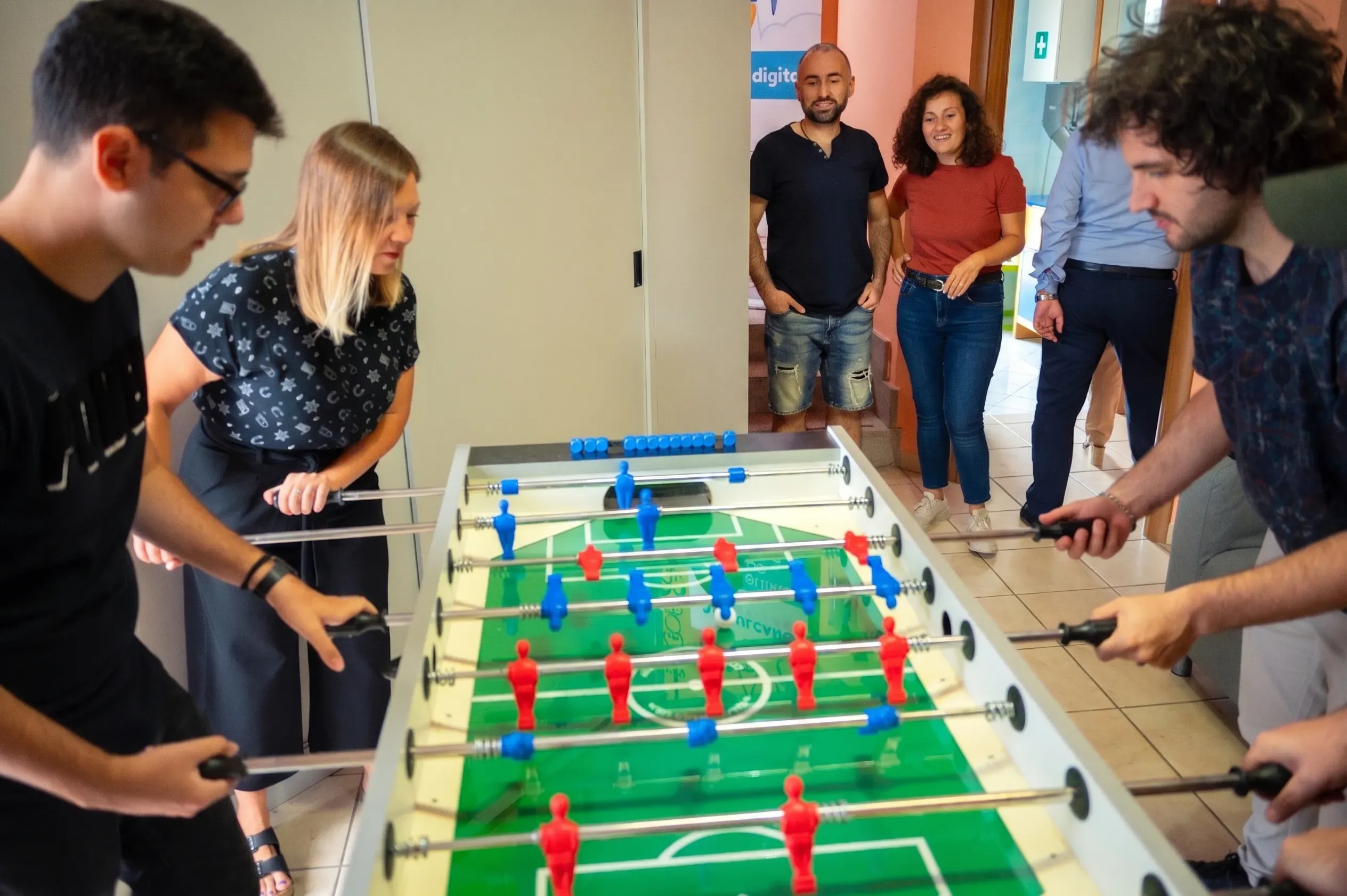 The Code This Lab team relaxing over a game of foosball in the office