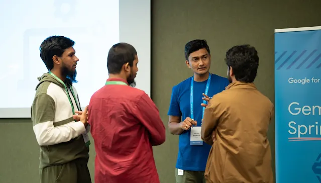 A man with blue shirt explaining something to other three men.