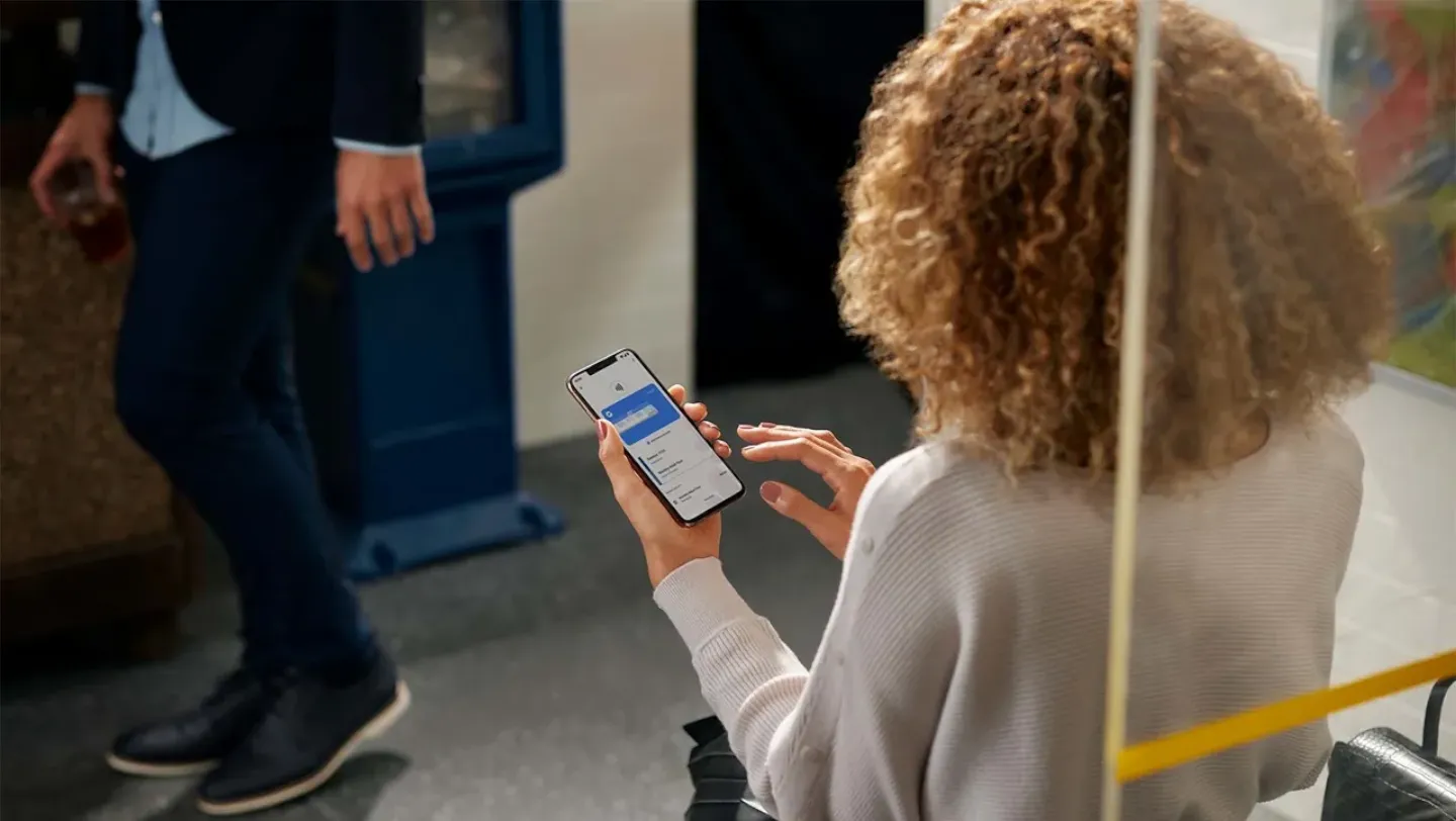 Woman using her Android smartphone and Google Wallet to view ticket reservations.